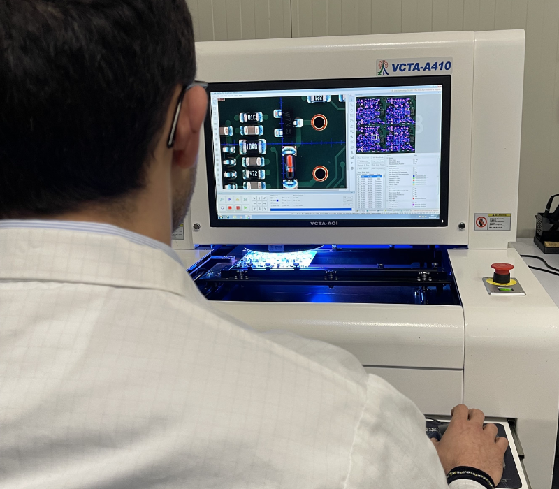 Professional technician performing Automated Optical Inspection (AOI) on printed circuit boards to ensure quality.